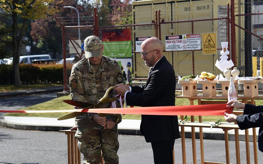 Col. Andrew Roddan, commander of the 374th Airlift Wing, and James Potach, senior vice president of Schneider Electric Sustainability Business, officially open a combined heat and power plant at Yokota Air Base, Japan, on Nov. 3.