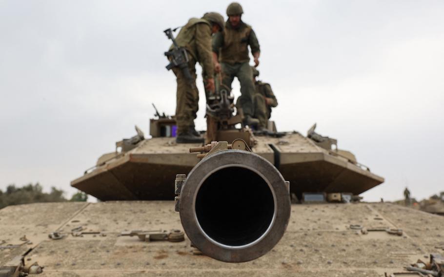 Israeli army soldiers are positioned with their Merkava tanks near the border with the Gaza Strip in southern Israel on Oct. 9, 2023.  