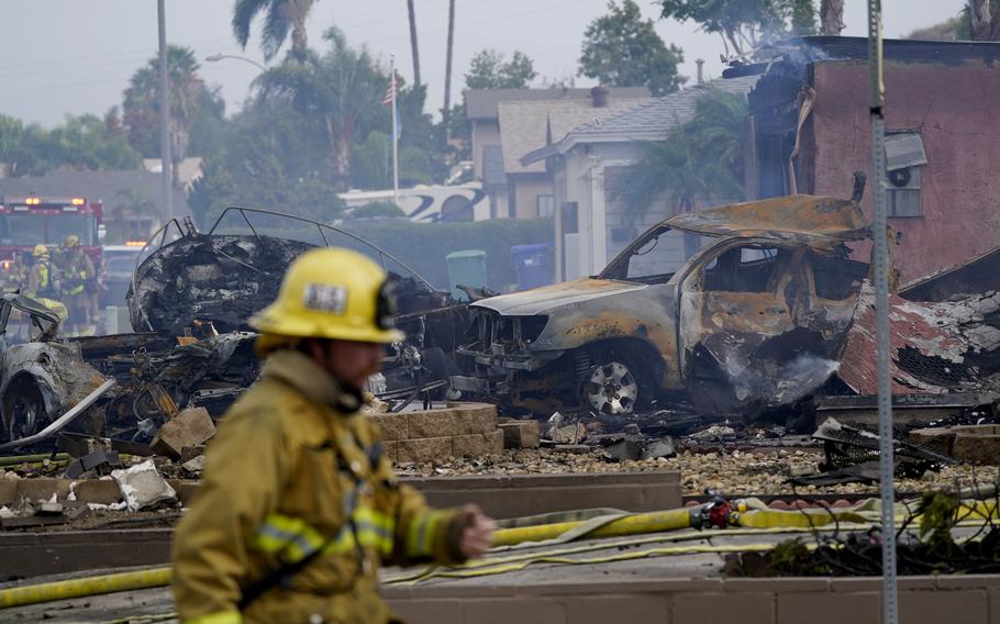 Fire crews work the scene of a small plane crash, Monday, Oct. 11, 2021, in Santee, Calif. At least two people were killed and two others were injured when the plane crashed into a suburban Southern California neighborhood, setting two homes ablaze, authorities said.