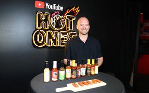 “Hot Ones” host/co-creator Sean Evans with a bunch of wings and hot sauces.