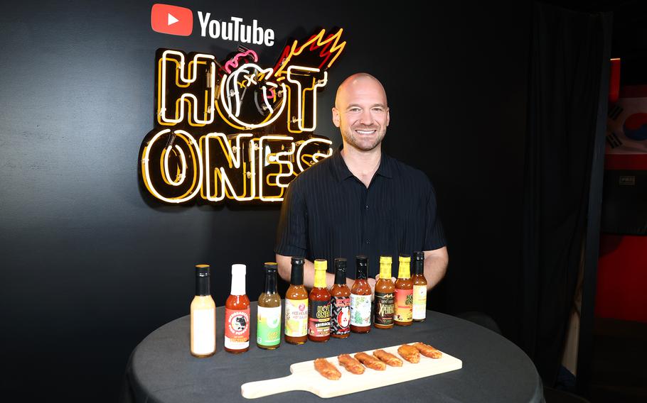“Hot Ones” host/co-creator Sean Evans with a bunch of wings and hot sauces.