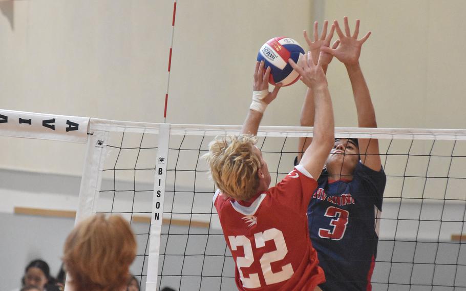 American Overseas School of Rome's Parker Huber and Aviano's Xavier Fox both jump with hands well above the net Saturday, Oct. 15, 2022. Huber scored the point, but the Saints won the match.