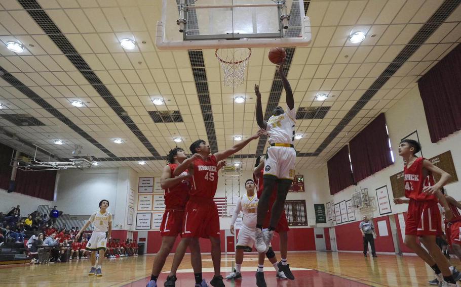 Robert D. Edgren's O'moj Reeves skies for a shot against the Nile C. Kinnick defense during Saturday's DODEA-Japan boys basketball game. The Red Devils won 64-26.