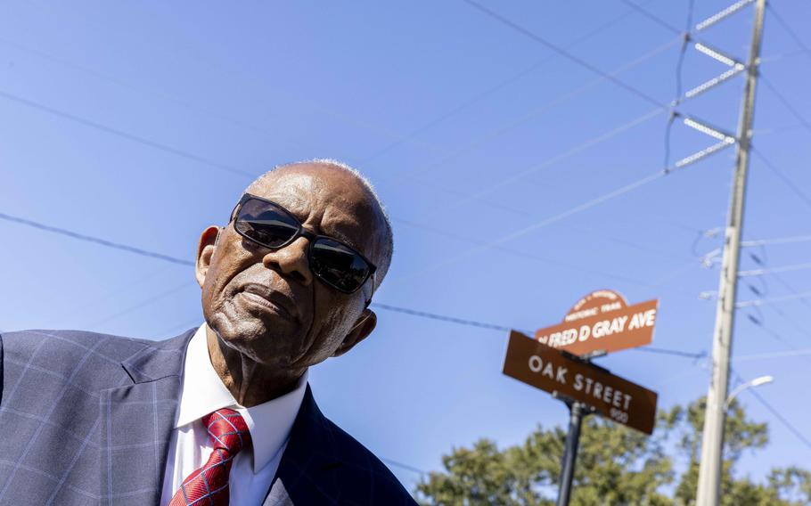 Fred Gray poses with the street renamed in his honor at the Fred D. Gray Avenue dedication ceremony, Tuesday, Oct. 26, 2021, in Montgomery, Ala. The civil-rights attorney was honored with his name on the road previously known as W. Jeff Davis Avenue. (AP Photo/Vasha Hunt)