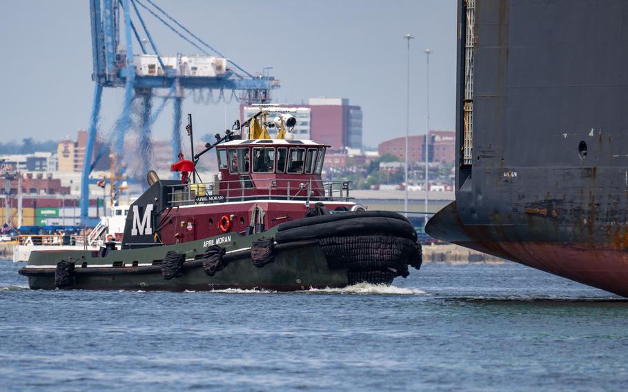 The tug April Moran escorts the Carmen vehicle carrier through the new temporary channel at the Francis Scott Key Bridge collapse site.