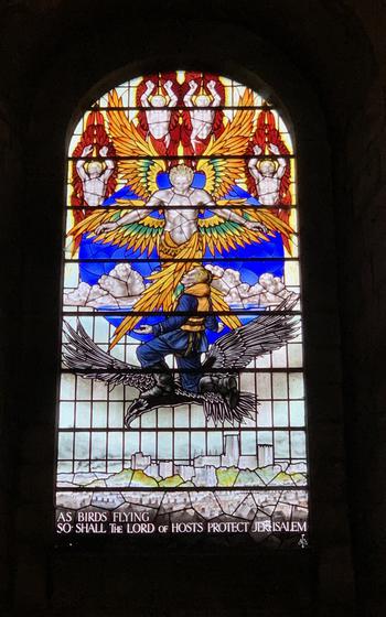 Window features stained glass illustration and reads “AS BIRDS FLYING SO SHALL THE LORD OF HOST PROTECT JERUSALEM”