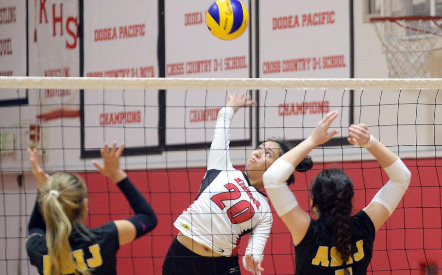 Nile C. Kinnick's Jenia Viles spikes between American School In Japan's Emm Liu and Brianne Roberts during Tuesday's Kanto Plain volleyball match. The Red Devils won in five sets.