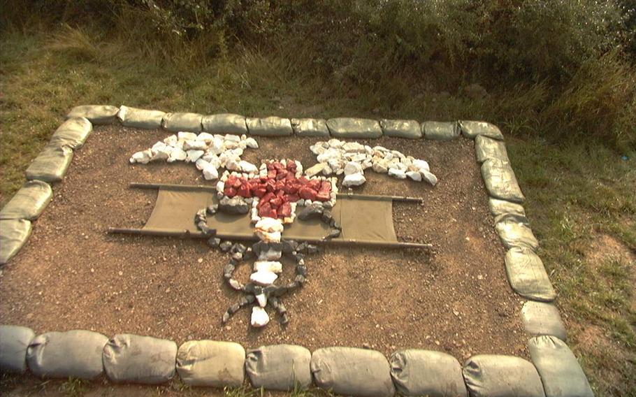 A makeshift replica of a badge with its insignia, created out of rocks on the ground.