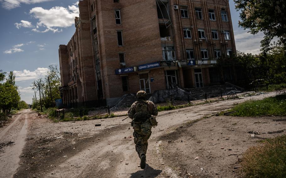 A Ukrainian sniper unit runs in a street of Maryinka, a town on the frontlines of the war with Russia, on May 17. 