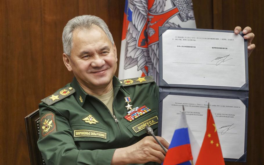 Russian Defense Minister Sergei Shoigu shows his signature under a roadmap for military cooperation between Russia and China during a video call with Chinese Defense Minister Wei Fenghe in Moscow, Russia, Tuesday, Nov. 23, 2021.