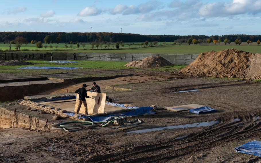 Senior Airman Logan E. Wilson, left, with the 786th Civil Engineer Squadron, and Army Sgt. William Castro, with the 12th Combat Aviation Brigade, clean a catchment area at an excavation site in Wistedt, Germany, Oct. 30, 2023, where the Defense POW/MIA Accounting Agency is hoping to recover the remains of U.S. service members lost in WWII.