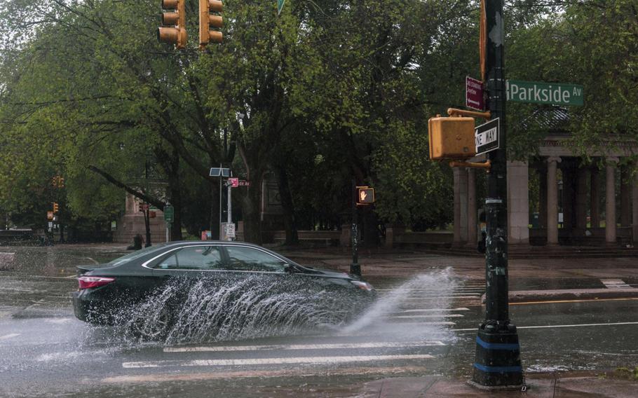 A vehicle travels through a flooded street during tropical storm Henri in the Brooklyn borough of New York on Aug. 22, 2021.
