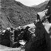 Guards look out over a sentry position in a hilly area.