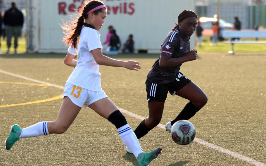 Yokota's Aubrey Oh and Nile C. Kinnick's Mayah Nyaku chase the ball during Wednesday's DODEA-Japan girls soccer match. The Red Devils won 4-1.