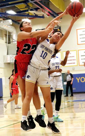 Yokota's Abby Vernon pulls down a rebound despite the best attempts of Nile C. Kinnick's Leona Turner.