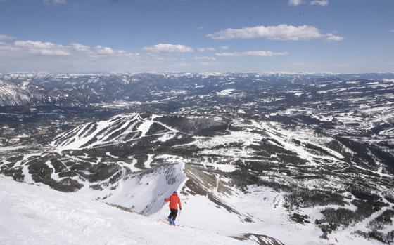 A skier descending Lone Mountain at Big Sky Resort has a commanding view of some of the property's less-challenging runs far below. 