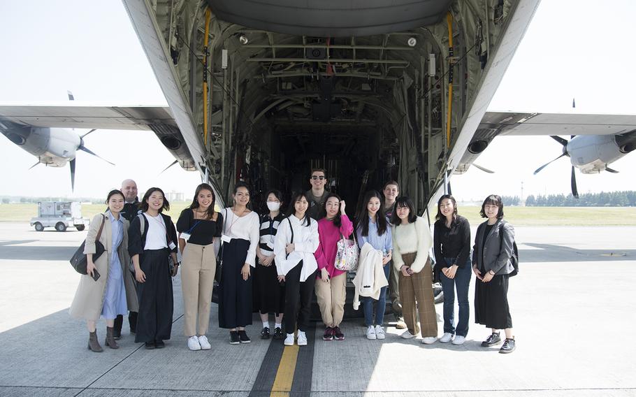 Japanese university students pose behind a C-130J Super Hercules during a tour of Yokota Air Base, Japan, Thursday, April 20, 2023. 