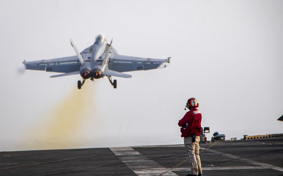 A Super Hornet launches from the flight deck of an aircraft carrier.