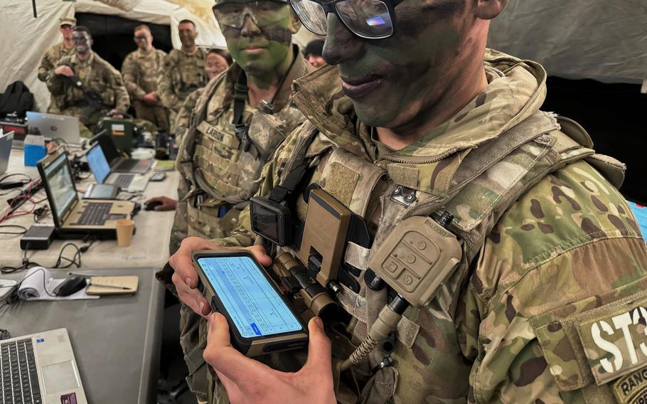 A soldier in a command post shows an app on a smartphone that helps forces stay in constant communication at the Joint Readiness Training Center at Fort Johnson, La., on Jan. 22, 2023. 