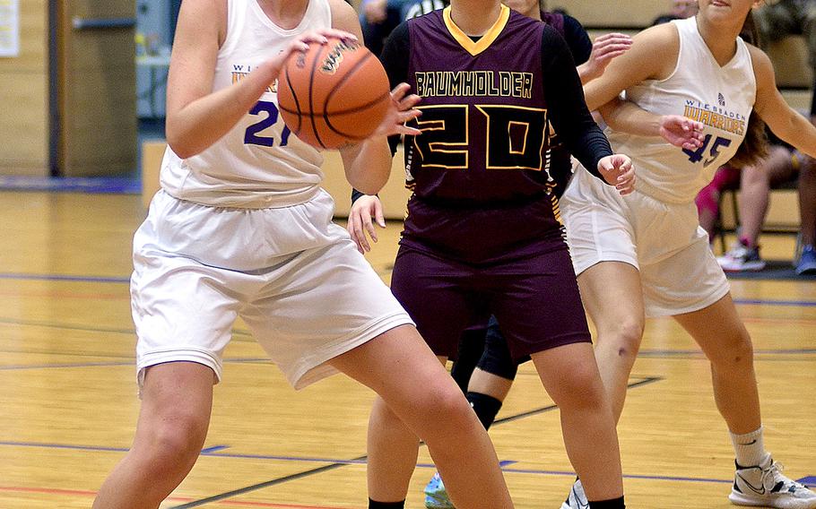 Wiesbaden’s Lyndsey Urick, left, backs down Baumholder’s Alex Barreto, center, during a game at Wiesbaden High School in Wiesbaden, Germany.