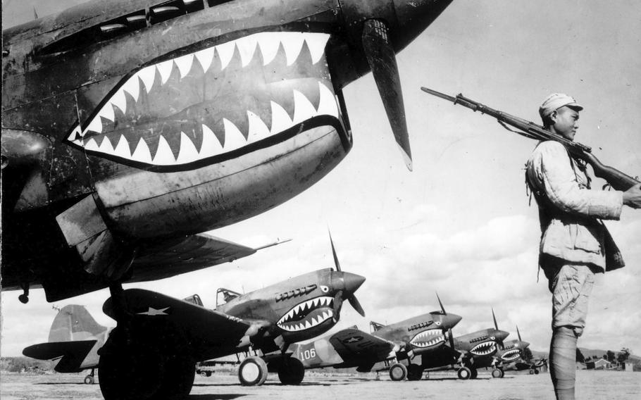 Guarded by a Chinese soldier, a squadron of Curtiss P-40 fighter planes, decorated with the typical shark face of the famed Flying Tigers, are lined up at an unknown airbase in China in 1943. 