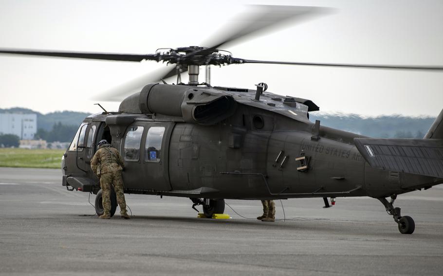 A U.S. Army pilot shuts the door to a UH-60 Black Hawk at Yokota Air Base, Japan, June 3, 2019. 