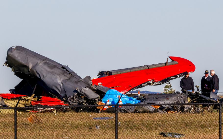 Officials, including those from the Federal Aviation Administration, survey damage from a Boeing B-17 Flying Fortress and a Bell P-63 Kingcobra crash a day earlier at the Dallas Executive Airport on Sunday, Nov. 13, 2022.