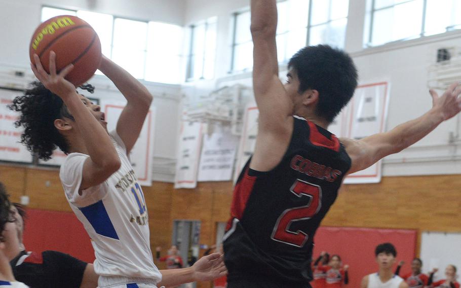 Yokota's Royce Canta goes up for a shot against E.J. King's Nolan FitzGerald during Saturday's DODEA-Japan boys basketball game. The Panthers won 67-57.