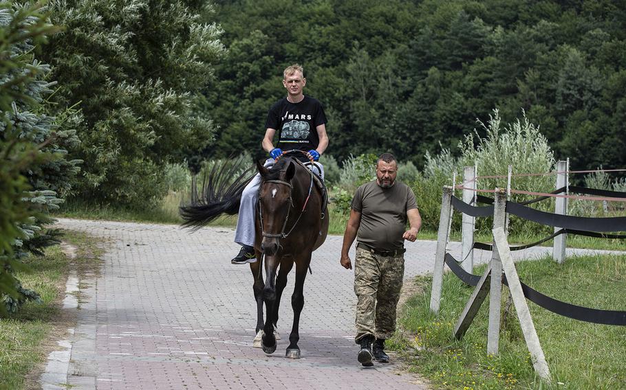 Irkha guides Dimitro, 36, during a therapy riding session. 
