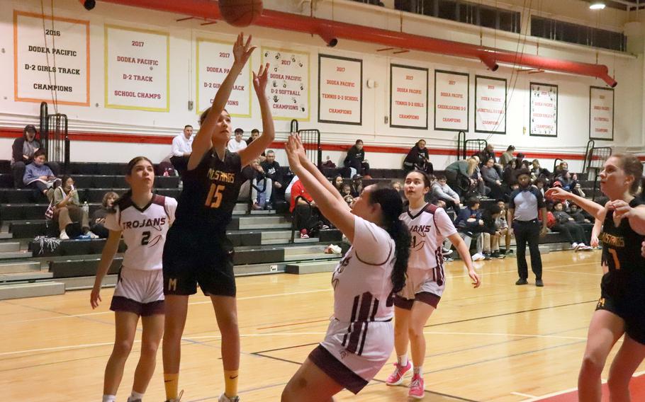 American School In Japan's Alice Phillips shoots over Zama defenders during Tuesday's Kanto Plain girls basketball game. The Trojans rallied late to win 34-32.