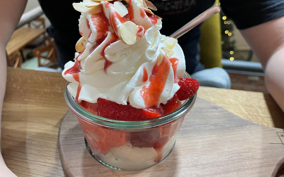 A strawberry ice cream sundae in a glass bowl.