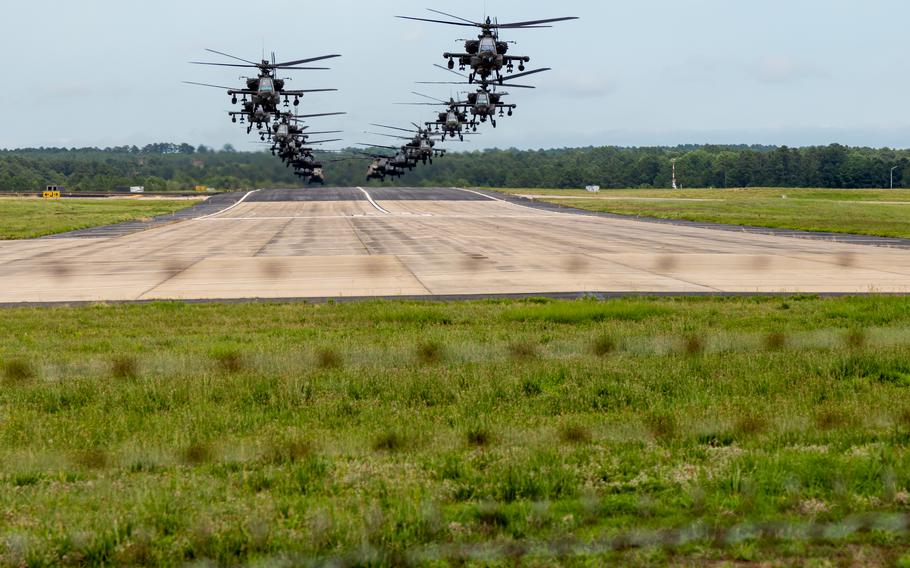 Helicopters in two lines fly over the airfield at Fort Bragg.