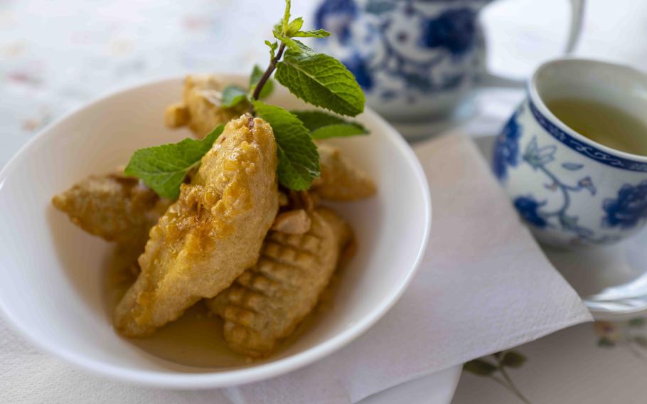 Green tea complements fried banana with honey drizzle and peanuts, a delectable dessert at Bun Viet in Unterammergau, Germany. 