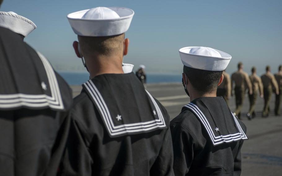 Sailors prepare to man the rails on the flight deck of the aircraft carrier USS Nimitz in San Diego, Feb. 26, 2021. 