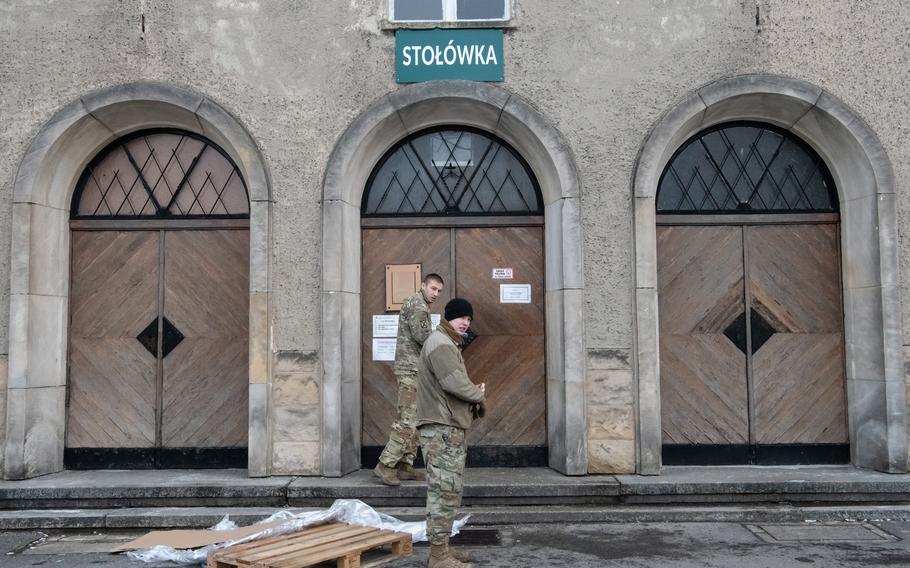 American soldiers enter the cafeteria at Camp Boles in Poland on Dec. 14, 2022. 