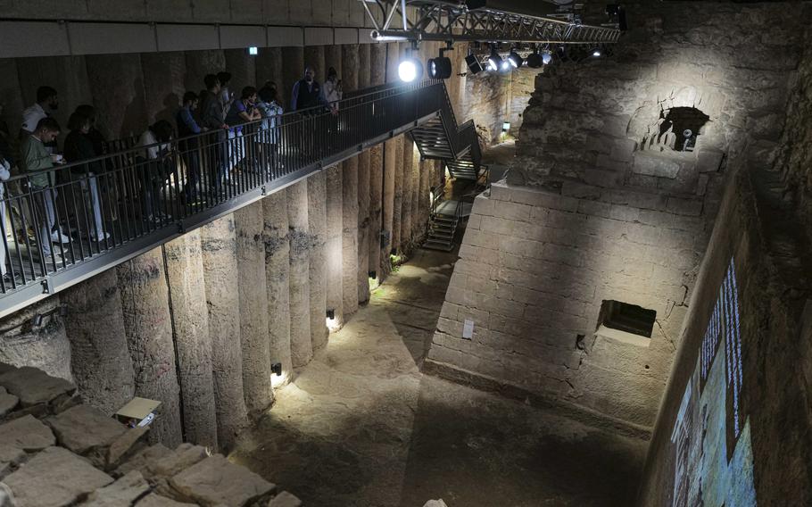 Visitors walk along an elevated walkway overlooking the buried moat and fortress wall, complete with a gun emplacement, at the Saar Historical Museum in Saarbruecken, Germany, on Oct. 19, 2023. The vantage point provides a view of the 16th century defense fortifications, offering a glimpse into the castle's past defensive prowess.