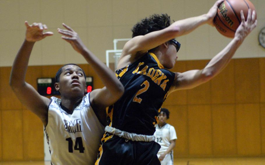 Kadena’s Angel Torrado snags a rebound in front of Zama’s Derek Smith. The Panthers beat the Trojans 43-32.