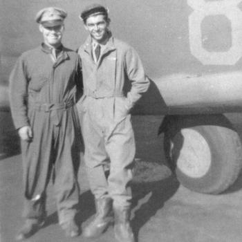 Sheppick and Kelly in flight suits in front of a plane.