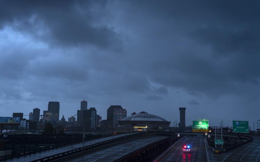 The downtown skyline is largely shrouded in darkness during the dawn as the electricity throughout Orleans Parish has failed after Hurricane Ida pummeled the area. 