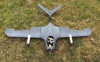 A 3D printed drone lies in a field.