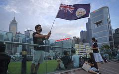 FILE - A protester waves Hong Kong British colony flag during continuing pro-democracy rallies in Tamar Park, Hong Kong, on Sept. 3, 2019. When the British handed its colony Hong Kong to Beijing in 1997, it was promised 50 years of self-government and freedoms of assembly, speech and press that are not allowed Chinese on the Communist-ruled mainland. As the city of 7.4 million people marks 25 years under Beijing's rule on Friday, those promises are wearing thin. Hong Kong's honeymoon period, when it carried on much as it always had, has passed, and its future remains uncertain, determined by forces beyond its control. (AP Photo/Vincent Yu, File)