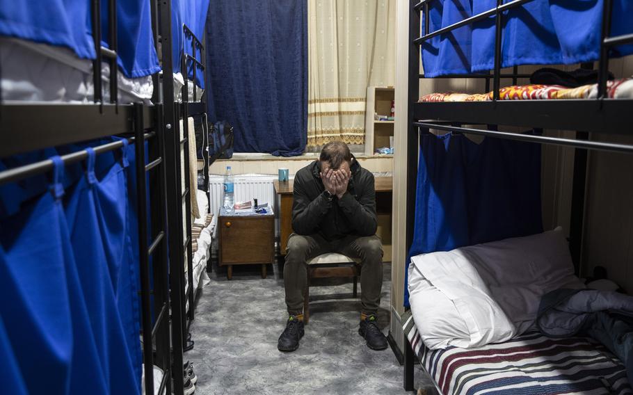 Anton, 26, fears for the safety of his pregnant wife, who returned to Russian-occupied Kherson. He sits by his bed at a shelter for internally displaced Ukrainians in Zaporizhzhia on Oct. 24. 