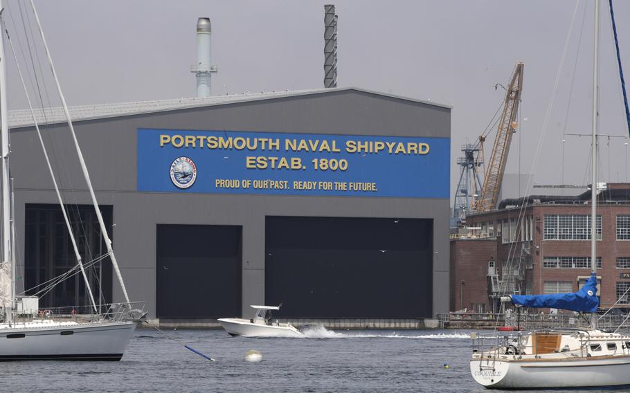 A small pleasure craft passes the Portsmouth Naval Shipyard, Tuesday, June 23, 2020, as seen from across the Piscataqua River in New Castle, N.H. A former naval police officer at the Portsmouth Naval Shipyard was sentenced Thursday, May 18, 2023, in federal court in Boston for threatening his ex-wife and her mother in Iowa. 