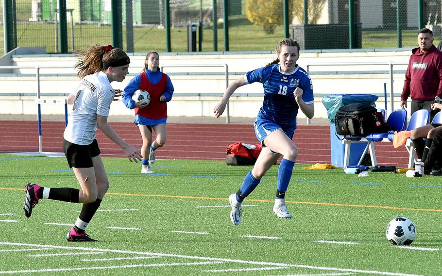 Kaiserslautern's Ryan Phillips, left, and Ramstein's Mary Lowe chase after a ball during the Royals' 7-0 win over the Raiders on Friday at Ramstein High School on Ramstein Air Base, Germany.