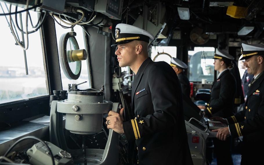 Ensign Seth Brock stands as conning officer on the cruiser USS Normandy as it pulls into Cherbourg, France, on Nov. 14, 2022, as part of the Gerald R. Ford Carrier Strike Group. 