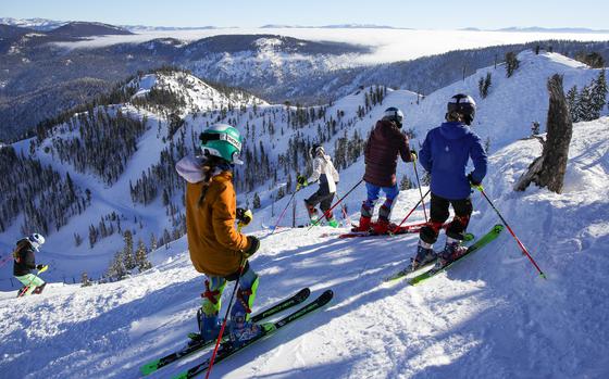 Skiers and snowboarders ride down the slopes from the KT-22 summit during the grand opening of Palisades Tahoe gondola line in Olympic Valley, Calif. on Dec. 16.  Residents and environmental groups are concerned about a proposal to turn the Palisades Tahoe (former Squaw Valley) into a year-round resort destination.