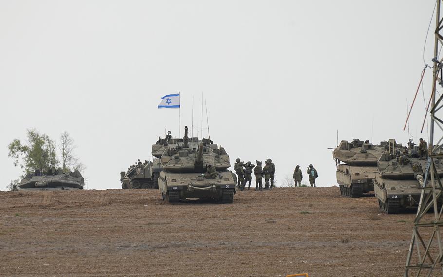 Israeli soldiers are seen in a staging ground near the Israeli Gaza border, southern Israel, Monday, Oct. 9, 2023. 