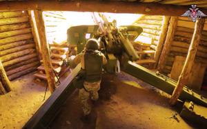 From inside a bunker, a soldier fires the howitzer.