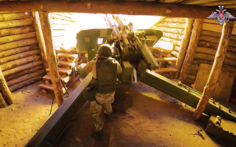 From inside a bunker, a soldier fires the howitzer.