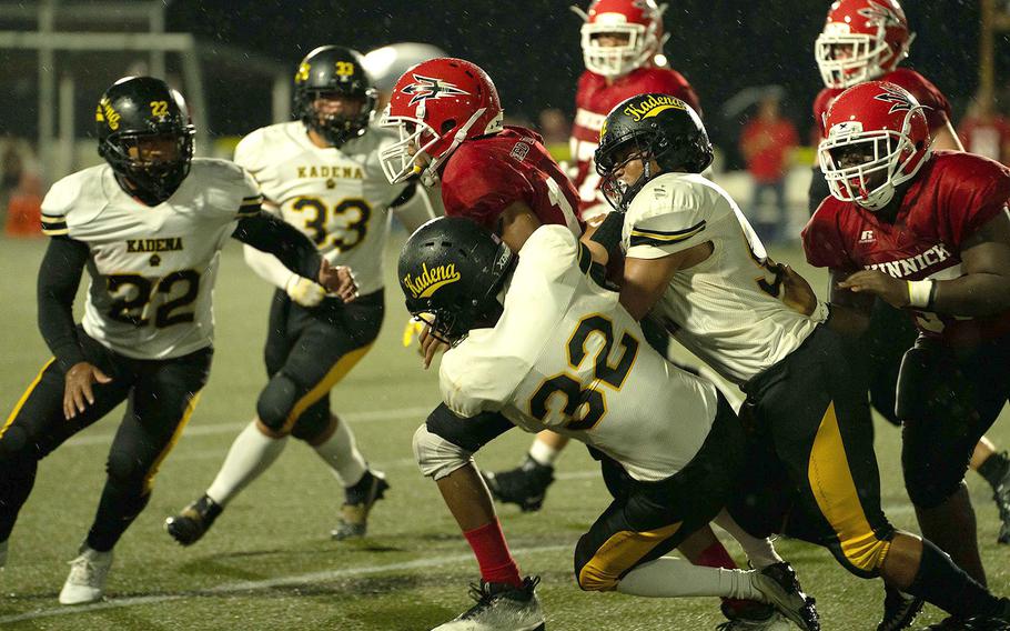 Nile C. Kinnick's Arashi Blocton gets gang-tackled by Kadena's defense.